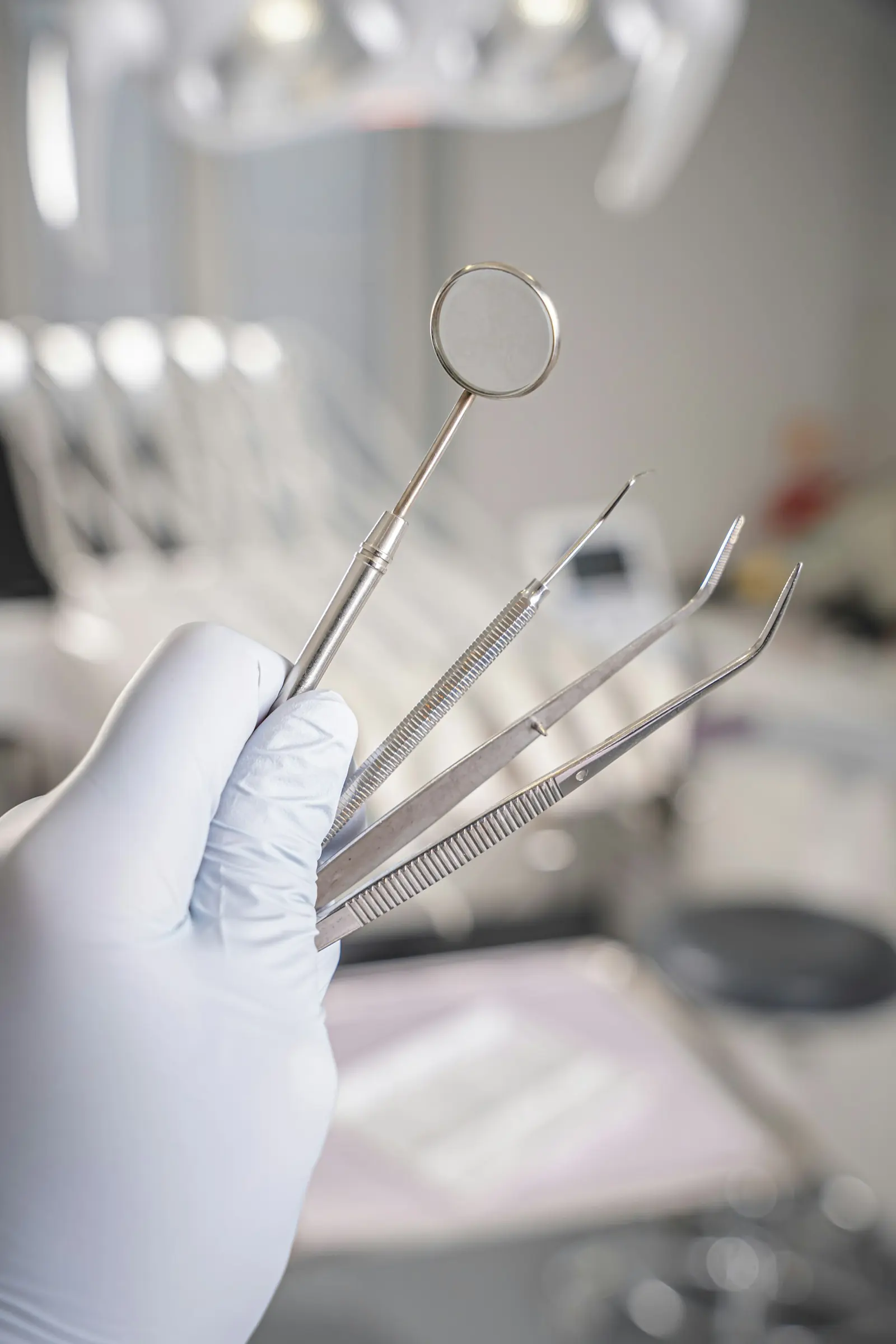 Dental instruments held in gloved hands