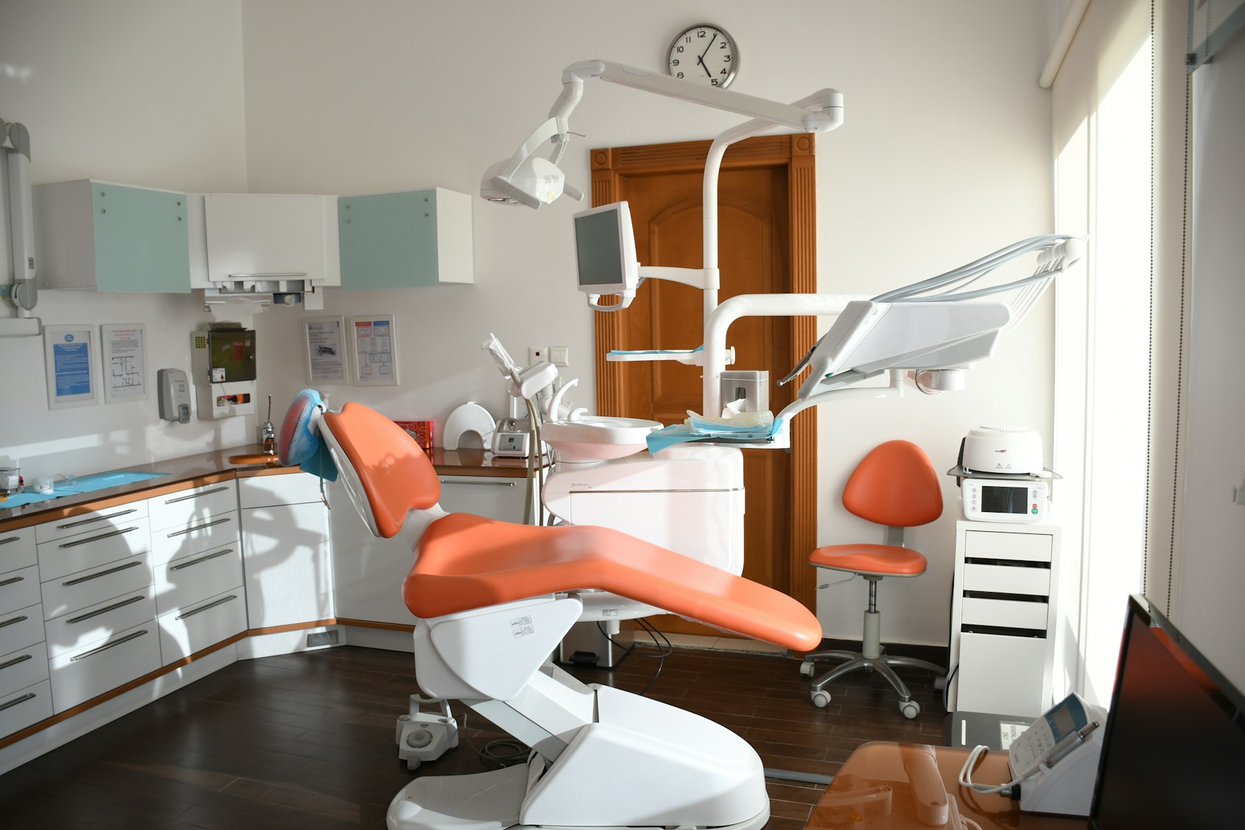 An orange dental chair in a treatment room