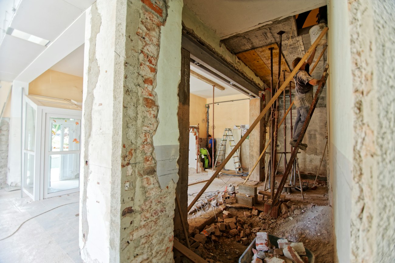 A worker on a ladder painting a room