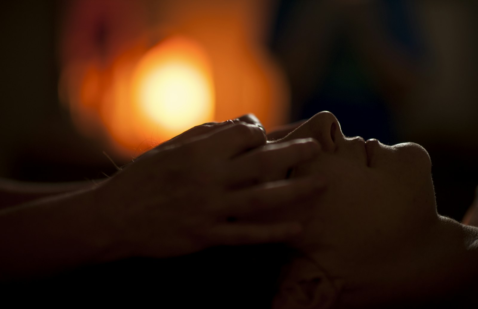A face massage in a dim treatment room